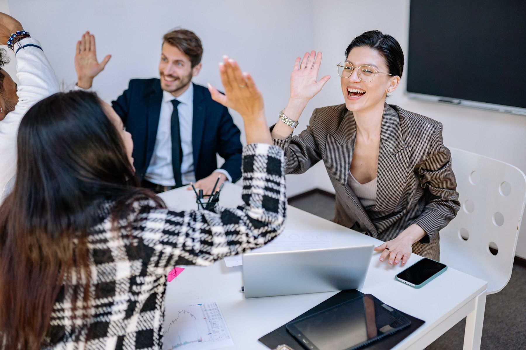 A happy office team celebrating a shared achievement with a high-five